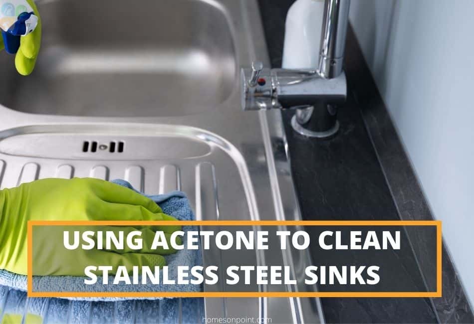 Man wearing green gloves cleaning stainless steel sink