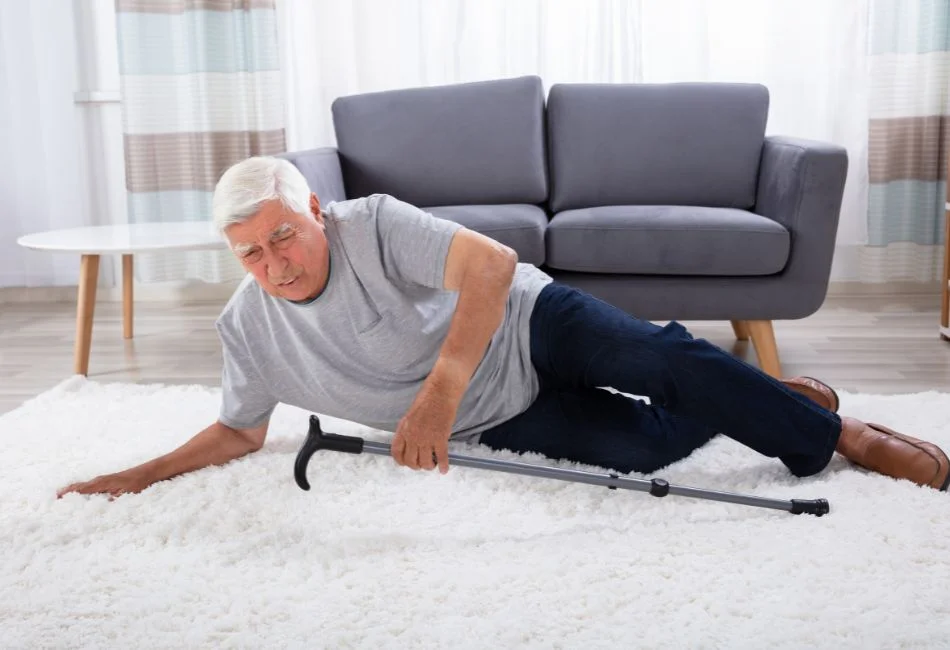 Elderly man falling on living room carpet