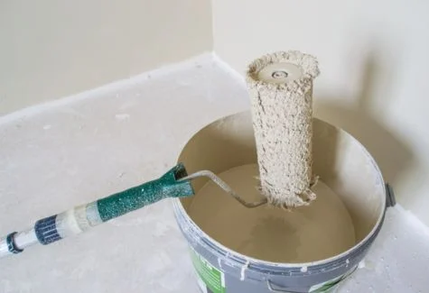 water based paint in bucket with paint brush